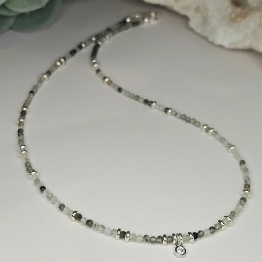 Delicate, faceted Green Rutile Quartz bead necklace with an AAA grade CZ pendant and silver toned stainless steel clasp.