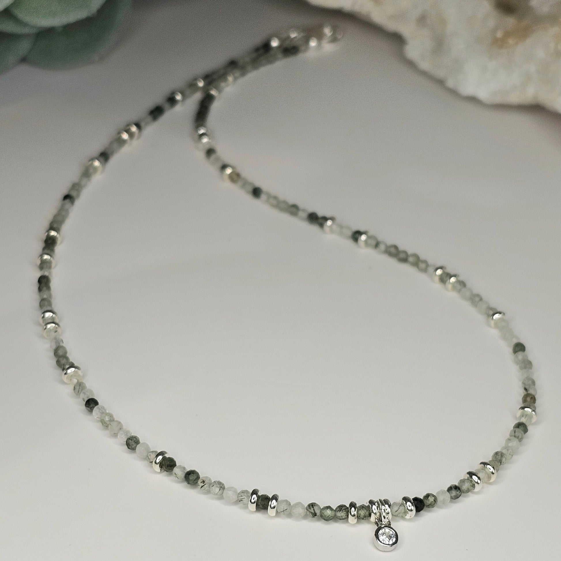 Delicate, faceted Green Rutile Quartz bead necklace with an AAA grade CZ pendant and silver toned stainless steel clasp.