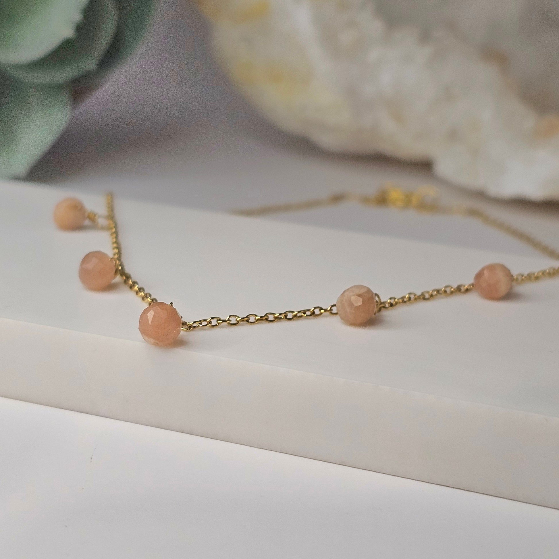 Fine gold toned stainless steel chain adorned with five dainty Sunstone beads.