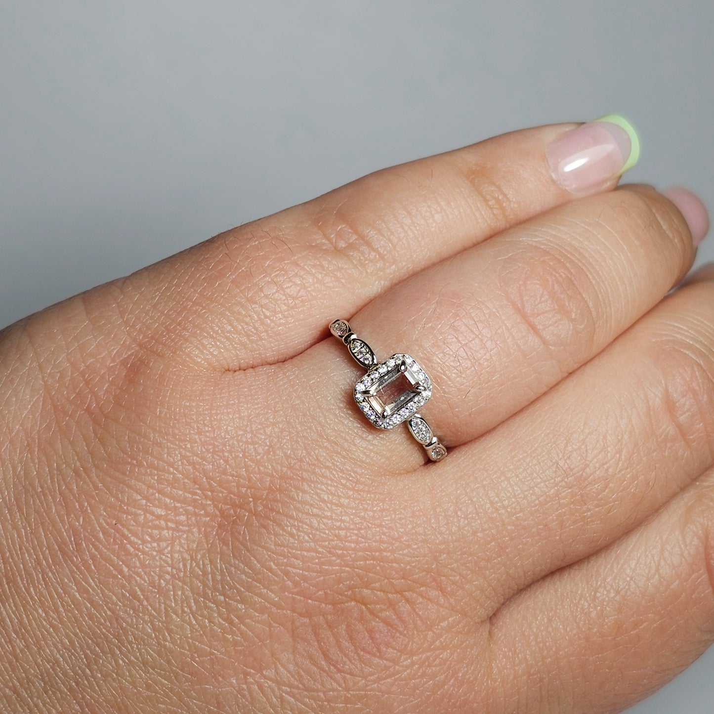 This petite adjustable ring is crafted from sterling silver and features a beautiful light pink Tourmaline baguette with a zircon accented crown and shoulders.