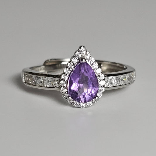 This adjustable ring is crafted from sterling silver and features a gorgeous pear shaped Amethyst centre stone with a Zircon accented crown and shoulder ring band.