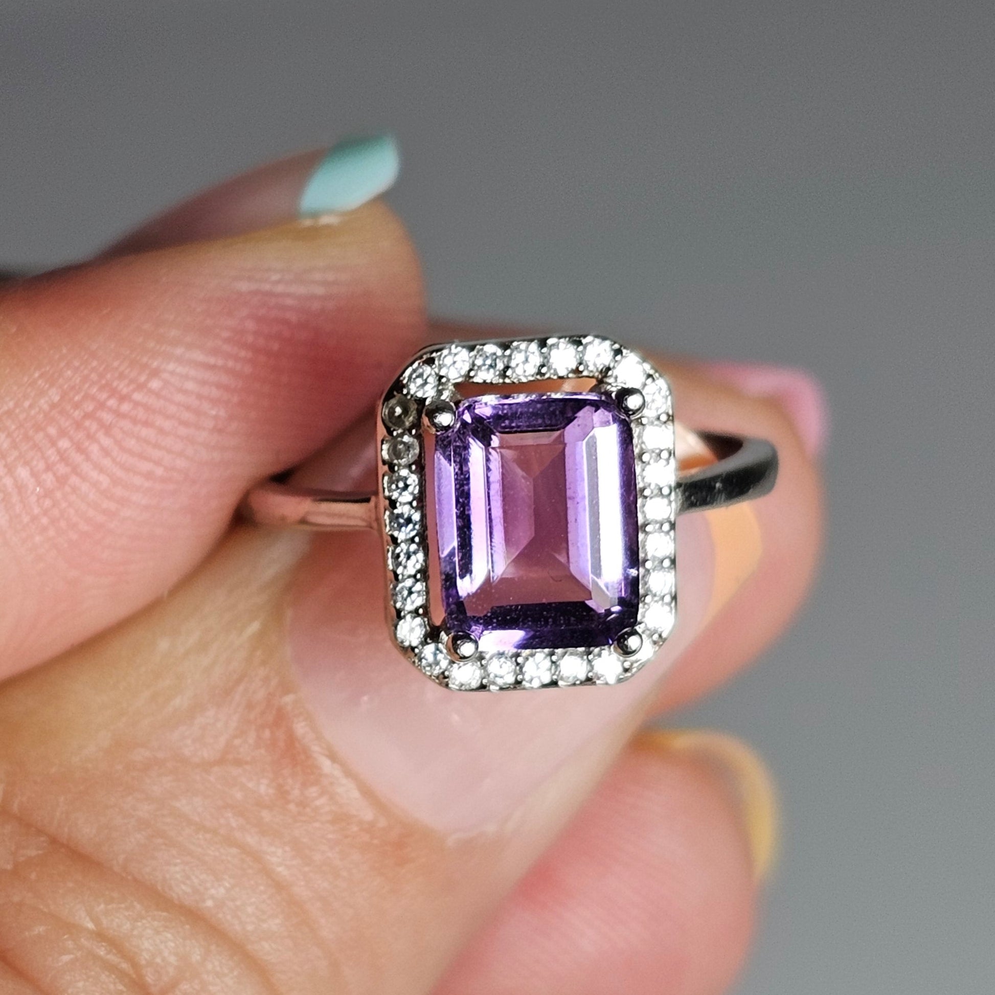This ring is crafted from sterling silver and features a gorgeous rectangular shaped Amethyst with a Zircon accented crown.