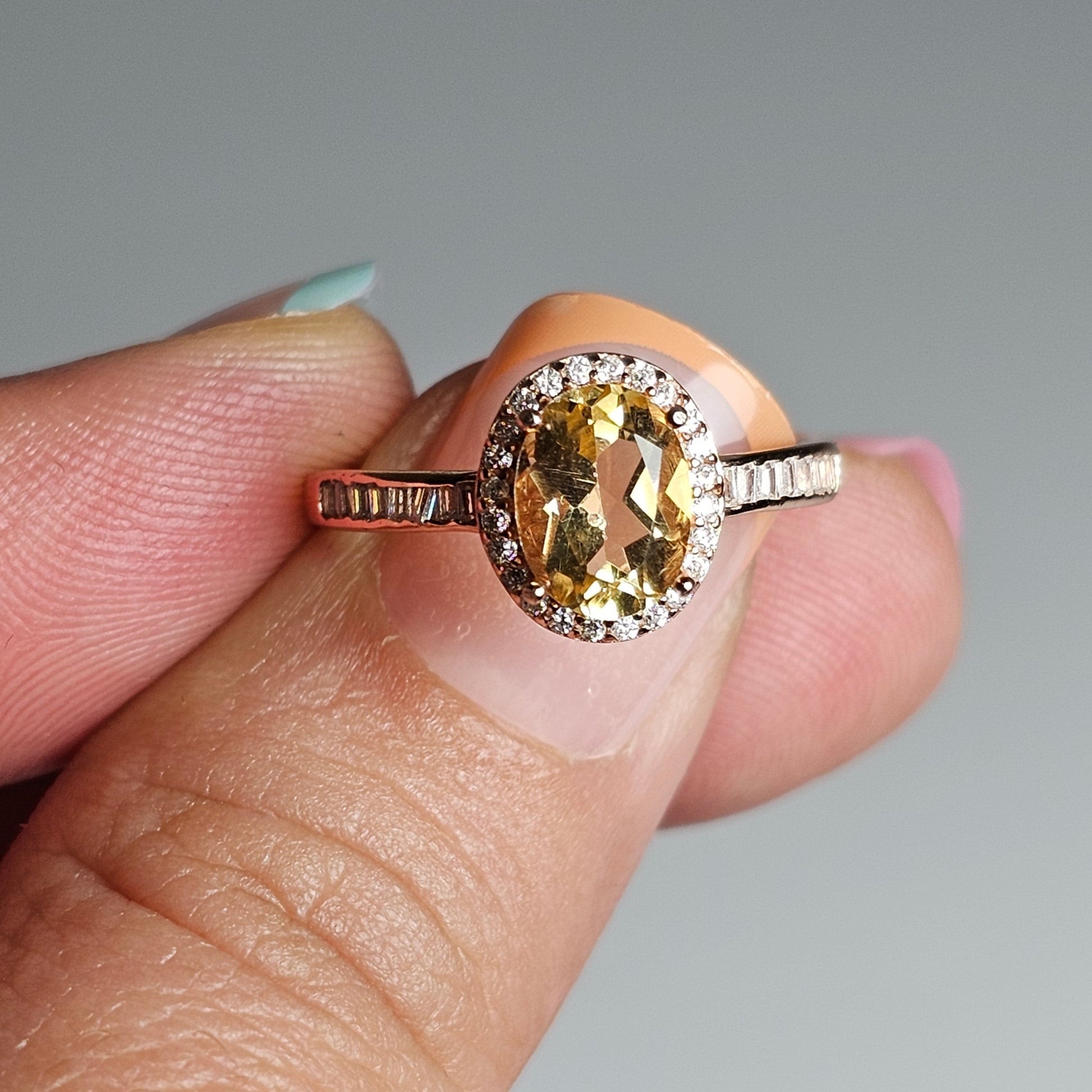 This adjustable ring is crafted from rose gold plated sterling silver and features a gorgeous oval Citrine centre stone with a Zircon accented crown and shoulder ring band.
