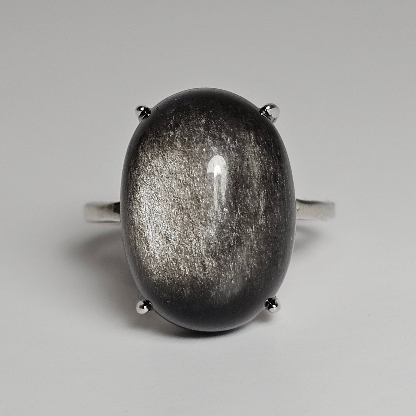 This adjustable bold ring is crafted from sterling silver and features a stunning oval shaped Silver Sheen Obsidian.