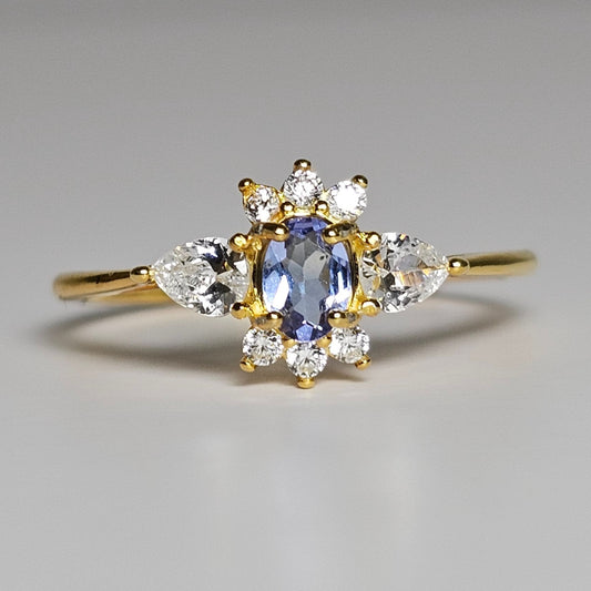 This adjustable ring is crafted from gold plated sterling silver and features a beautiful oval shaped Tanzanite centre stone surrounded with zircon.