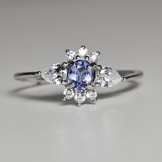 This adjustable ring is crafted from sterling silver and features a beautiful oval shaped Tanzanite centre stone surrounded with zircon.