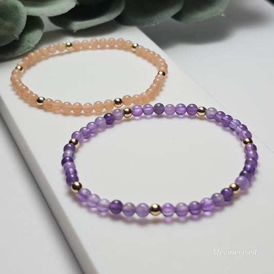 Minimal 4mm AAA grade Sunstone and Amethyst bracelets with gold accents styled in flat lay display.