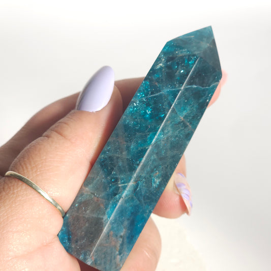 Blue Apatite tower held in hand showing size and natural flash in the stone.