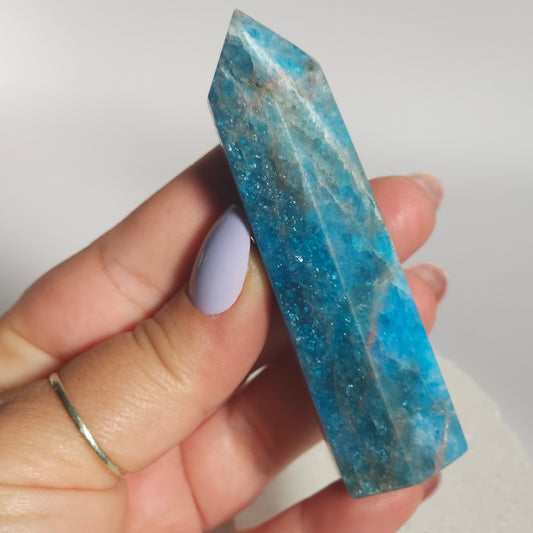 Blue Apatite tower held in hand showing size and natural flash in the stone.