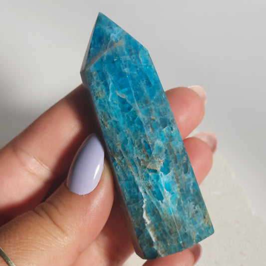 Blue Apatite tower held in hand showing size and colour.