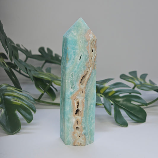 Blue Aragonite tower showing soft blue and green tones with natural pockets and druzy texture.