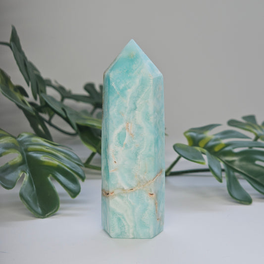 Blue Aragonite tower highlighting natural colour variation, earthy inclusions, and polished crystal surface.