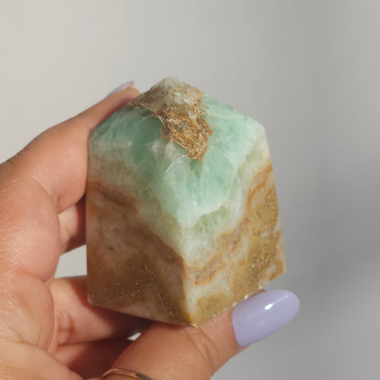 Caribbean Calcite Tower In Hand Close Up Showing Ocean Tones and Texture