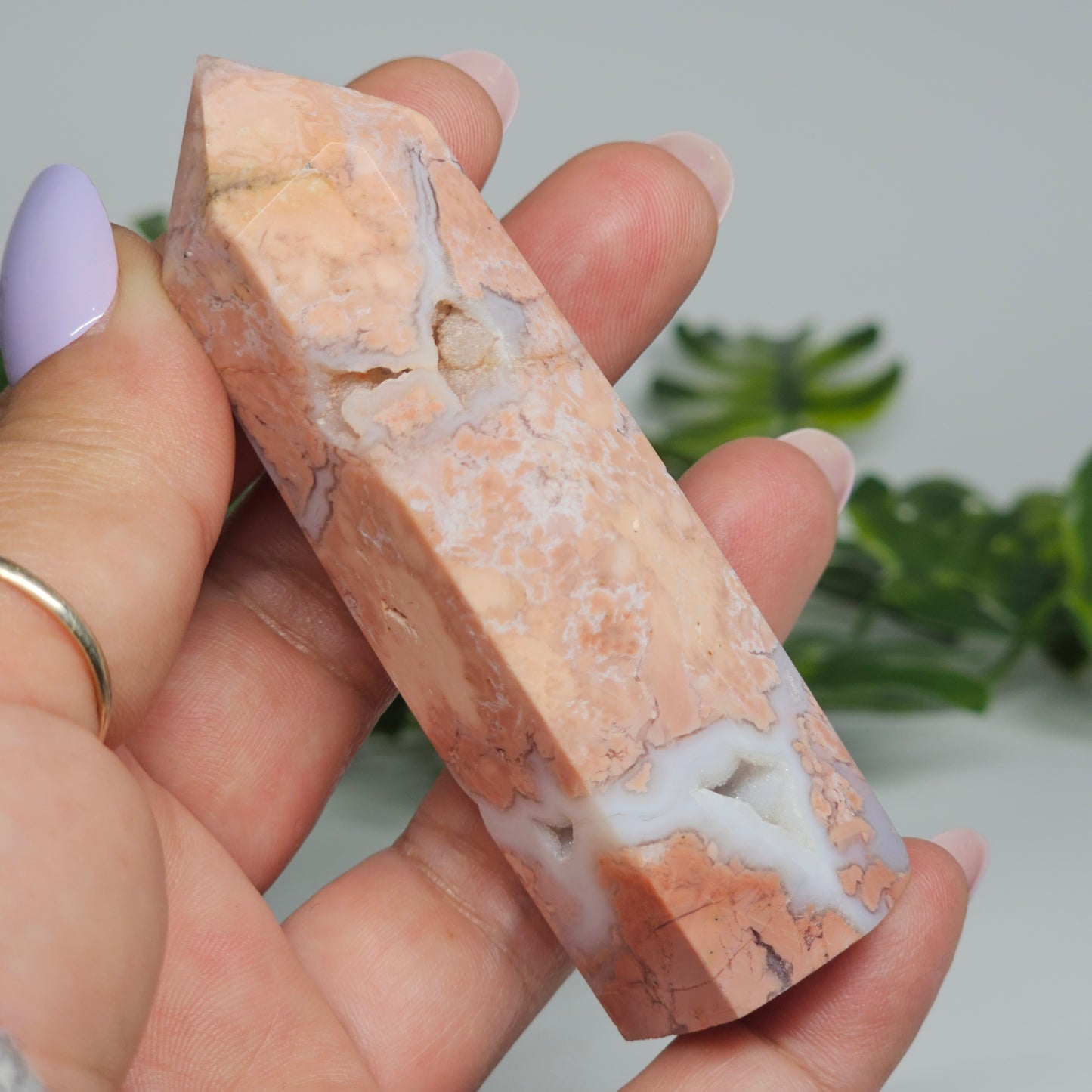 Cotton candy agate tower held in hand showing size, natural pastel colouring, and sugar druzy detail