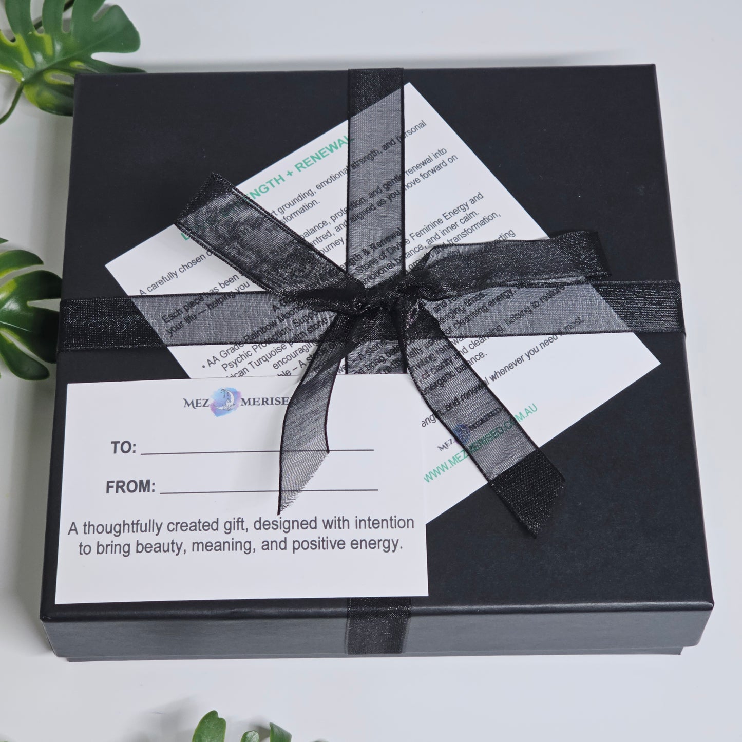 Closed crystal gift box with items inside including info card and to from gift card.