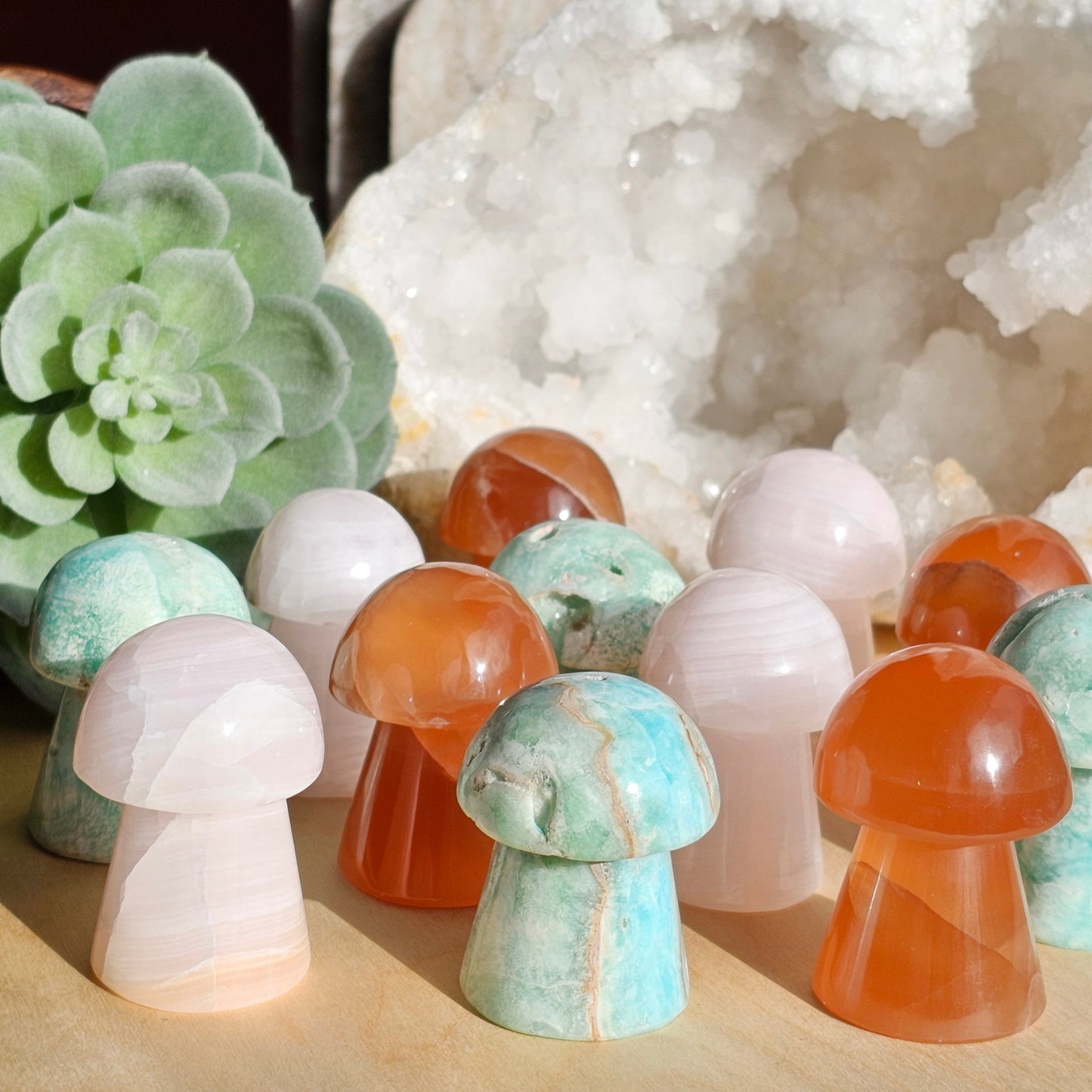 A mixed set of crystal mushroom carvings featuring Blue Aragonite, Pink Calcite, and Honey Calcite, each with unique natural colouring and smooth polished finishes. Together they represent calmness, emotional balance, and gentle uplifting energy.