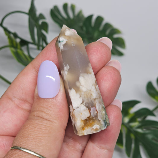 Flower Agate tower held in hand showing size and natural pattern.
