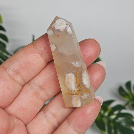 Flower Agate tower held in hand showing size and natural pattern.