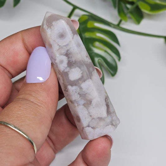 Flower Agate tower held in hand showing size and natural pattern.