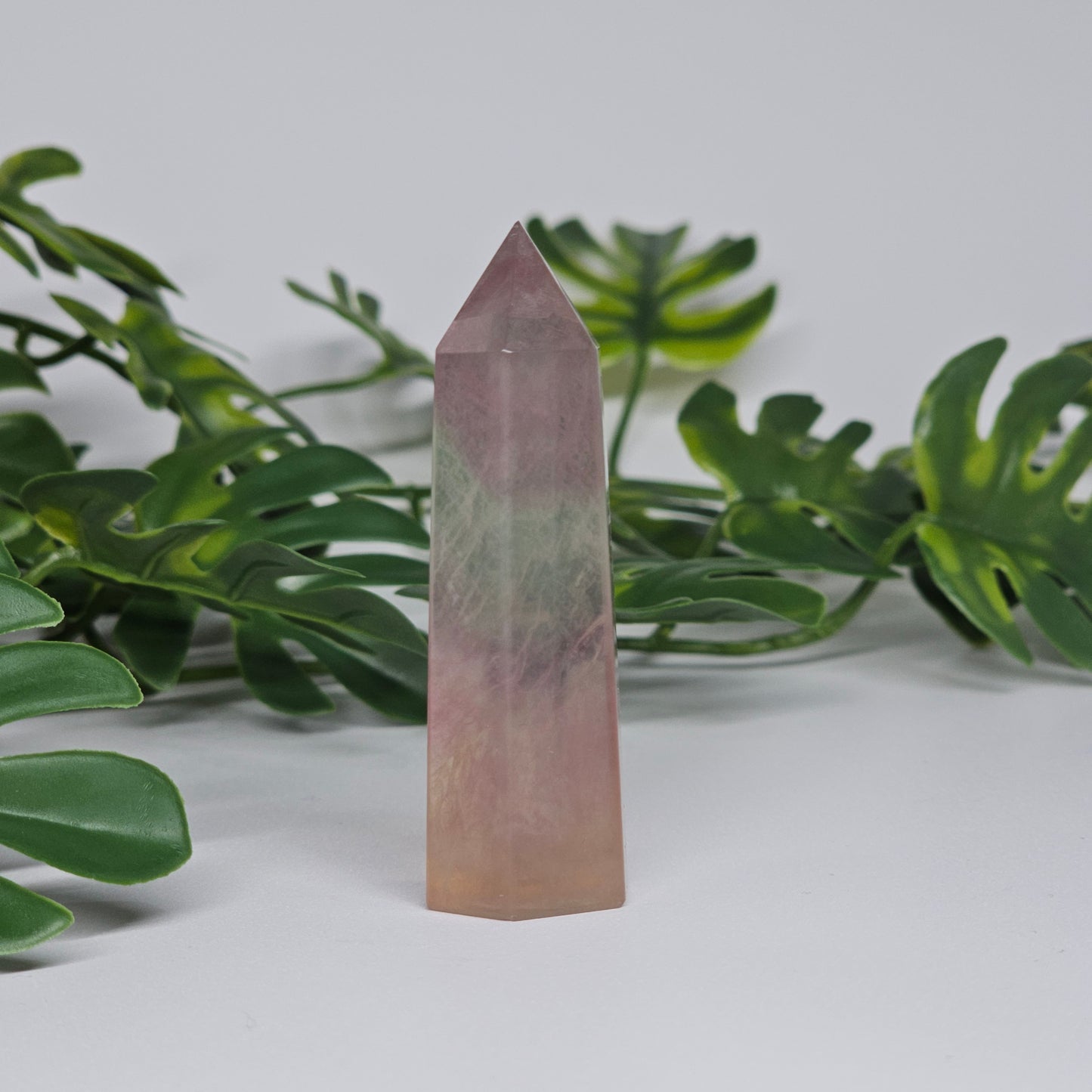 Fluorite crystal tower side view displaying layered colour zones and translucent natural formation
