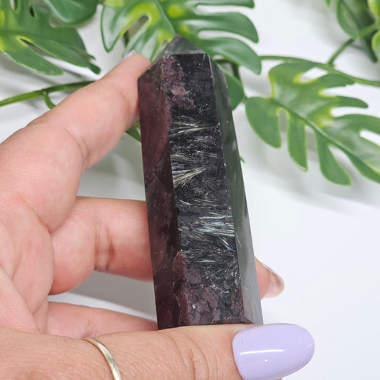 Garnet and Arfvedsonite crystal tower held in hand showing Arfvedsonite fireworks blades