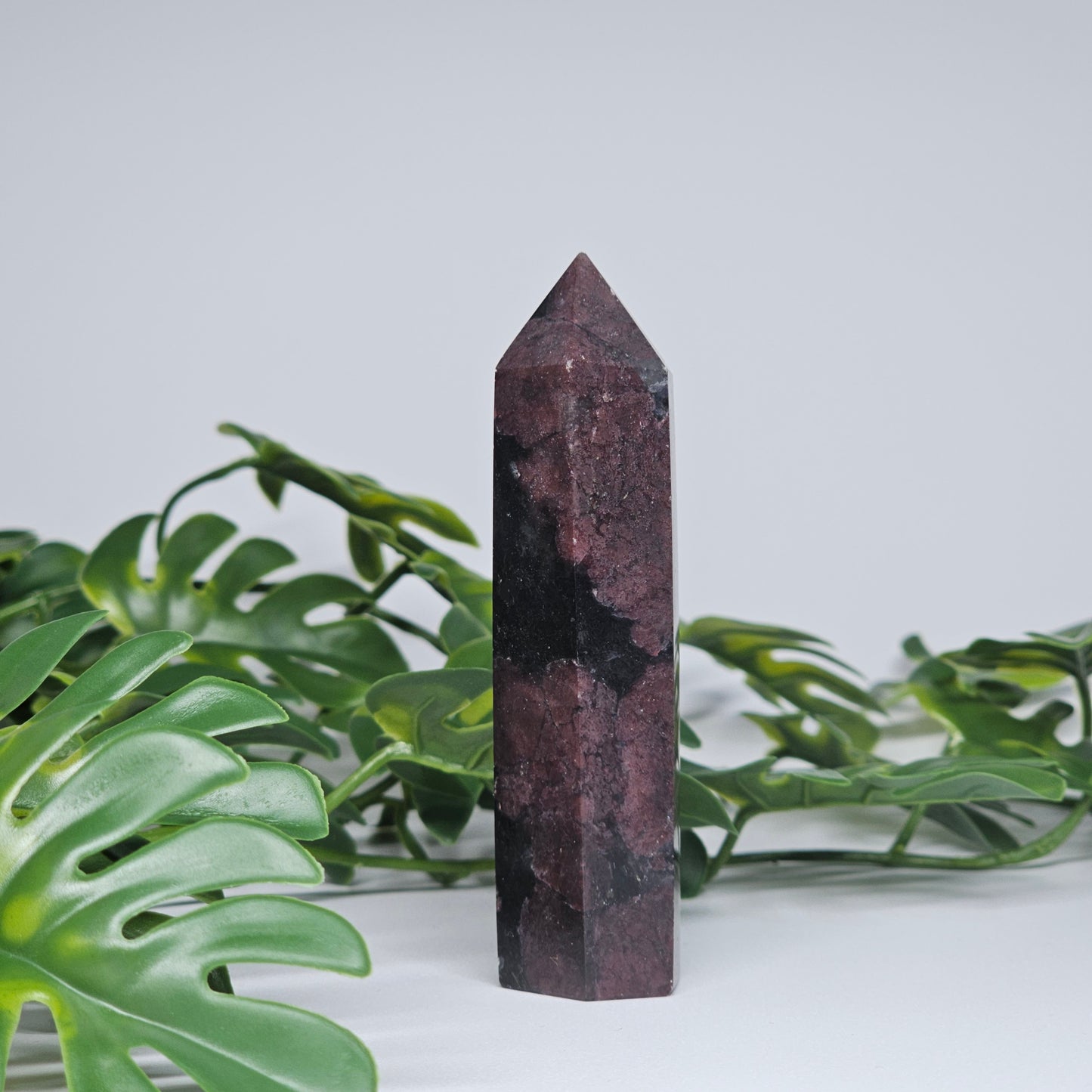 Garnet and arfvedsonite healing crystal tower with polished point and earthy tones