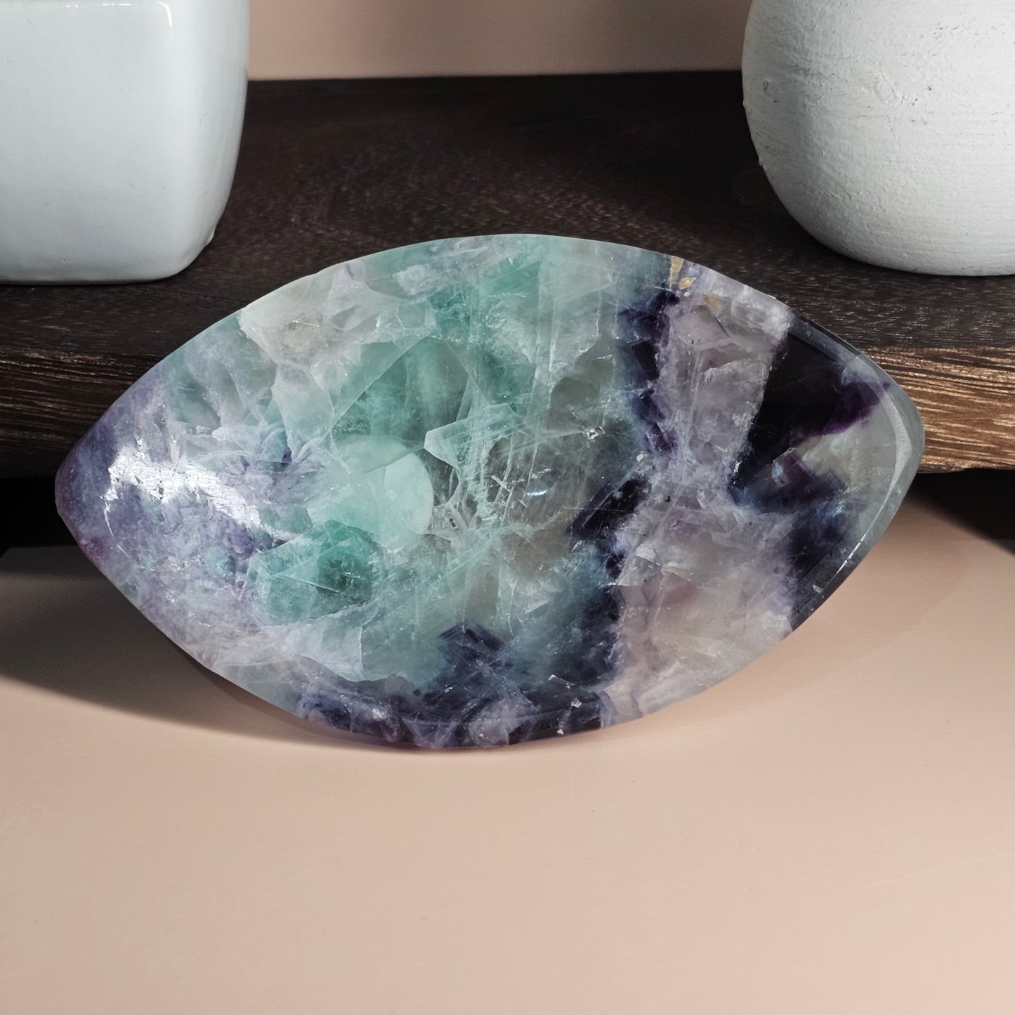 Propped front-facing display of the marquise Fluorite bowl highlighting its elongated elegant form, polished surface, and natural multi-colour zoning under balanced lighting.