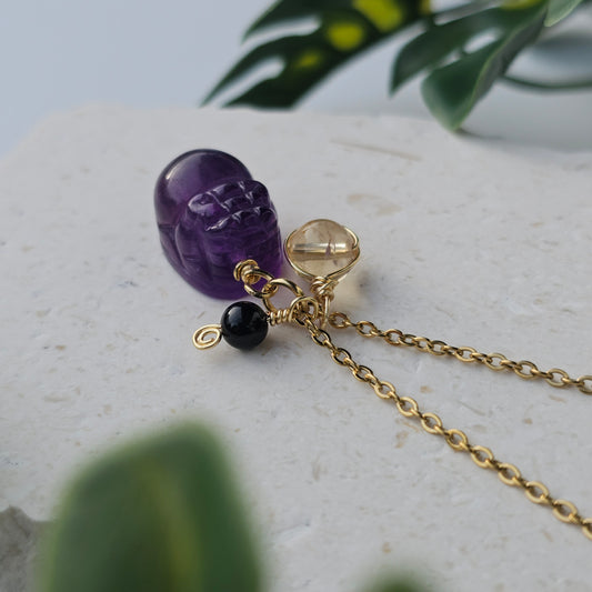 Top view of the Protected Prosperity Necklace showing Amethyst Pixiu with 6mm natural Citrine and 4mm Black Tourmaline beads on an 18k gold plated stainless steel chain