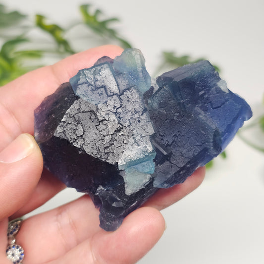Collector-grade Blue Fluorite crystal from Zhejiang, China showing intricate stepped cubic formations and deep sapphire-blue colour in hand.