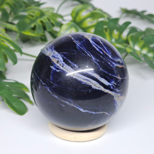 Side view of Sodalite sphere B on stand, showing its smooth polish and rich deep blue tones.