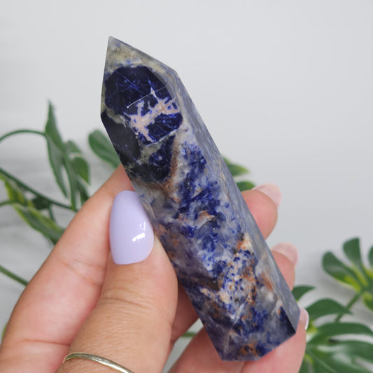 Sodalite tower held in hand showing size and natural pattern.