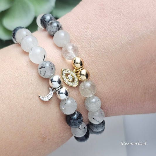 Black Rutile Quartz charm bracelets on wrist with gold and silver charms, 8mm natural gemstone jewellery for grounding and protection