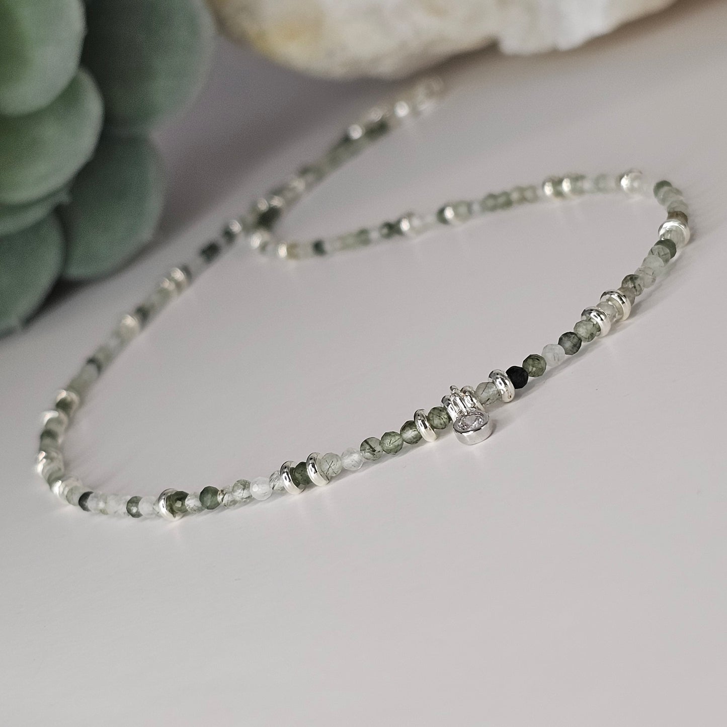 Delicate, faceted Green Rutile Quartz bead necklace with an AAA grade CZ pendant and silver toned stainless steel clasp.