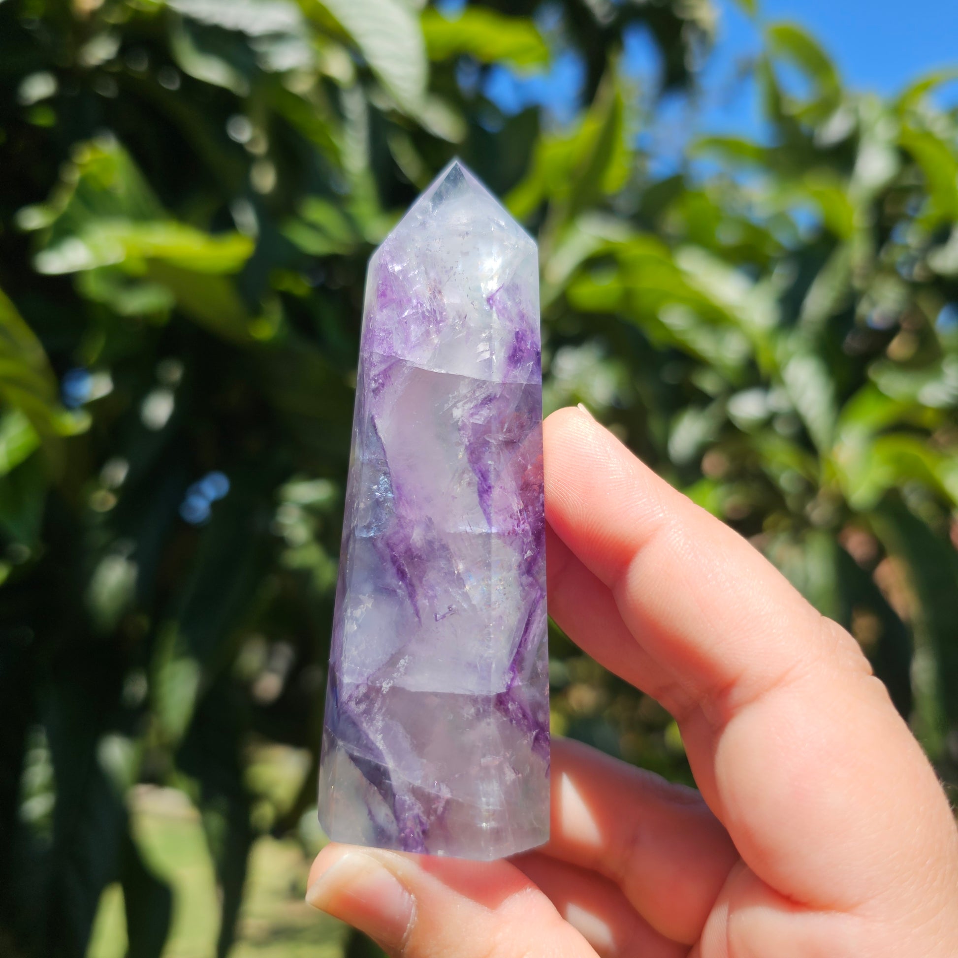 Spectacular clear Fluorite tower with vibrant purple, pastel blue &amp; pastel green banding. Also has beautiful rainbows throughout.