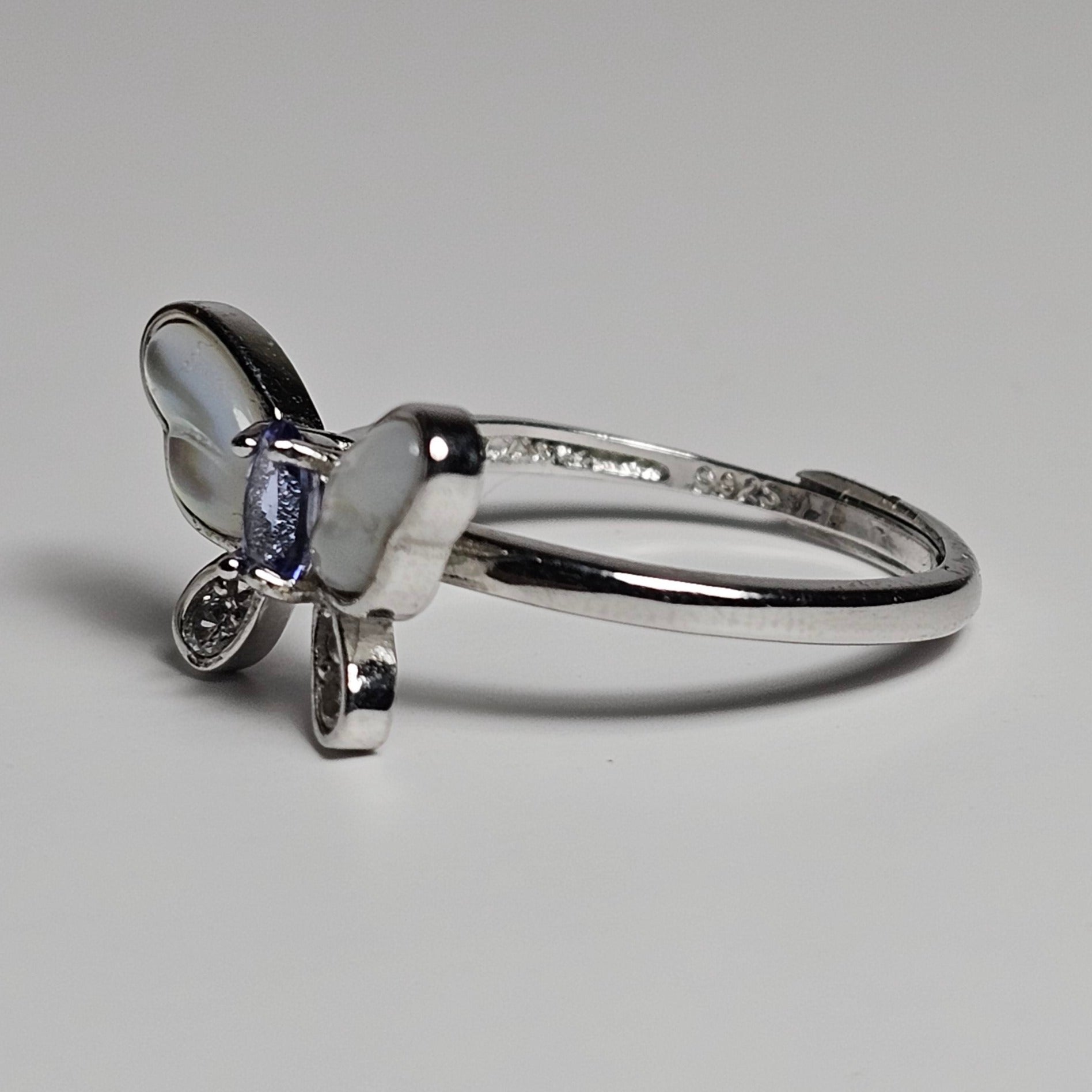 Adjustable sterling silver ring features a butterfly design with a stunning Tanzanite, shell and zircons.