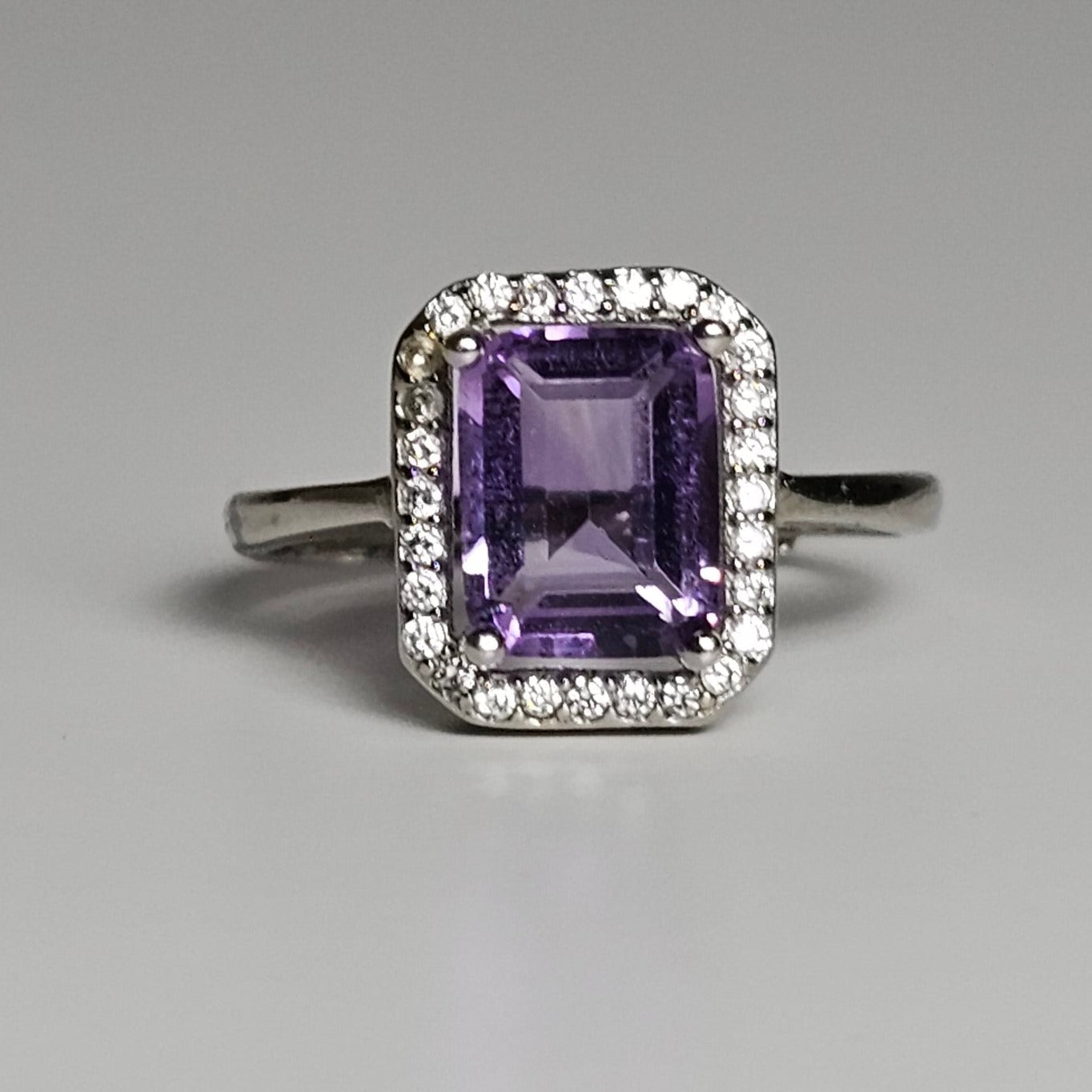 This ring is crafted from sterling silver and features a gorgeous rectangular shaped Amethyst with a Zircon accented crown.