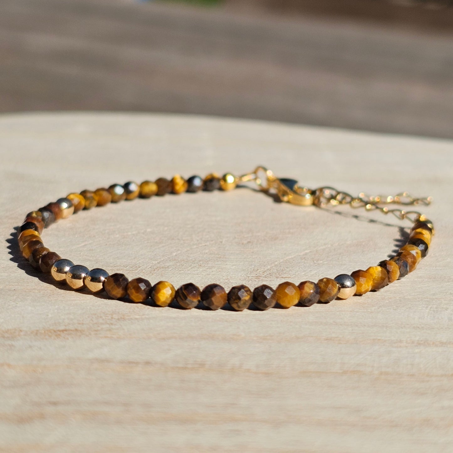 Delicate, faceted dainty Tiger's Eye and AAA grade gold plated Hematite bead bracelet with a gold stainless steel clasp and extender chain.