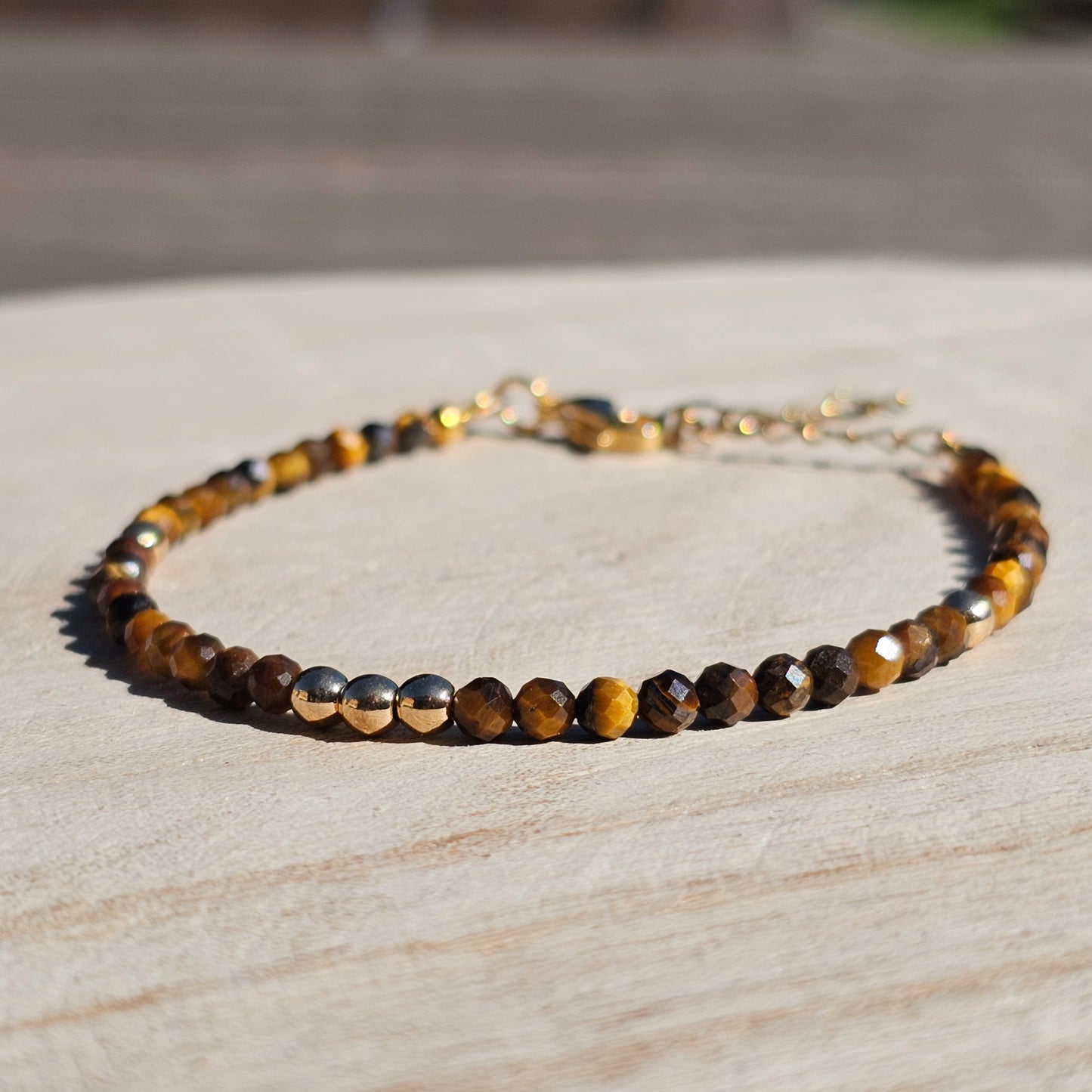 Delicate, faceted dainty Tiger's Eye and AAA grade gold plated Hematite bead bracelet with a gold stainless steel clasp and extender chain.