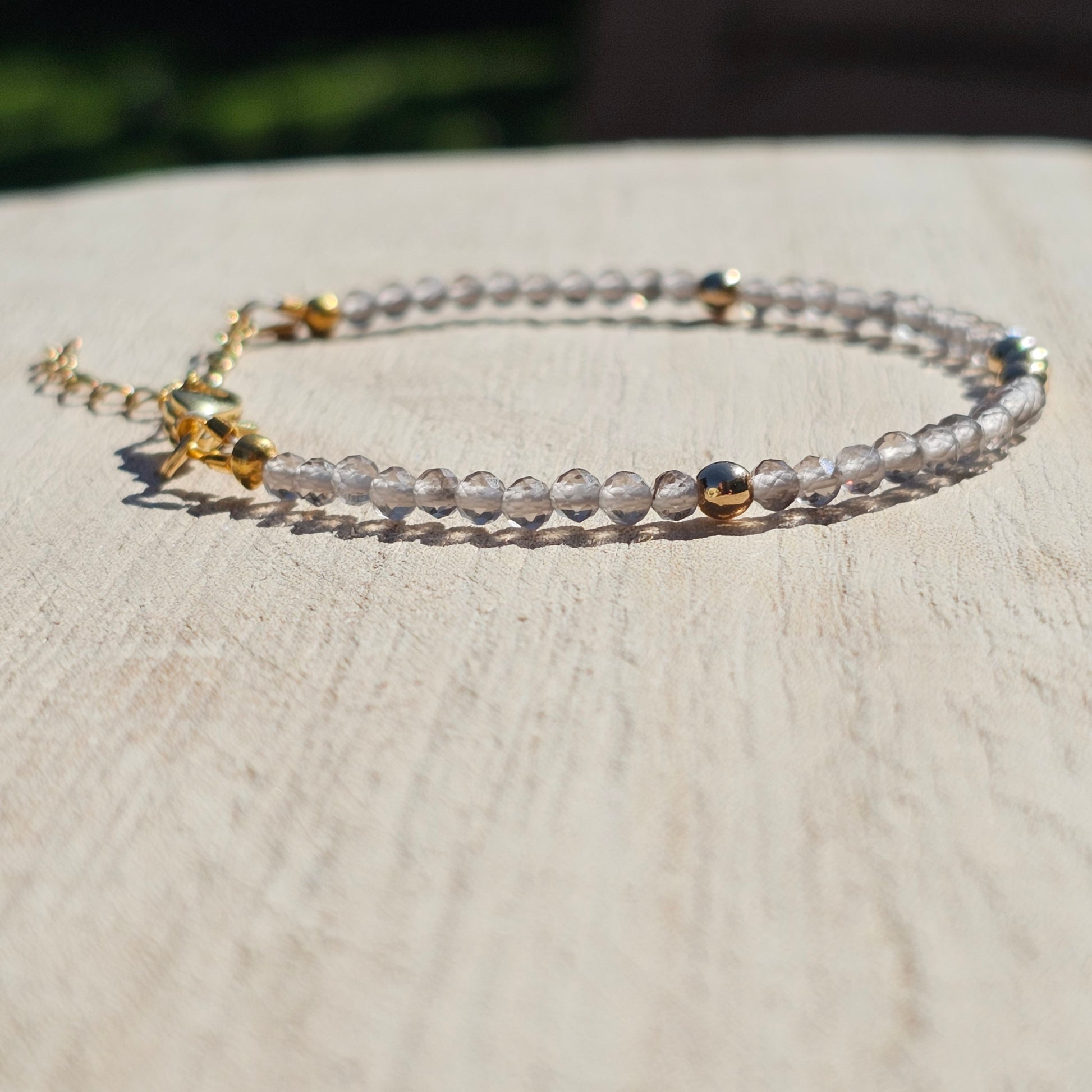 Delicate, faceted dainty Smoky Quartz and AAA grade gold plated Hematite bead bracelet with a gold stainless steel clasp and extender chain.