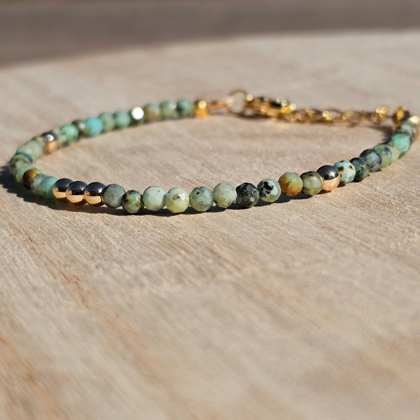 Delicate, faceted dainty African Turquoise and AAA grade gold plated Hematite bead bracelet with a gold stainless steel clasp and extender chain.