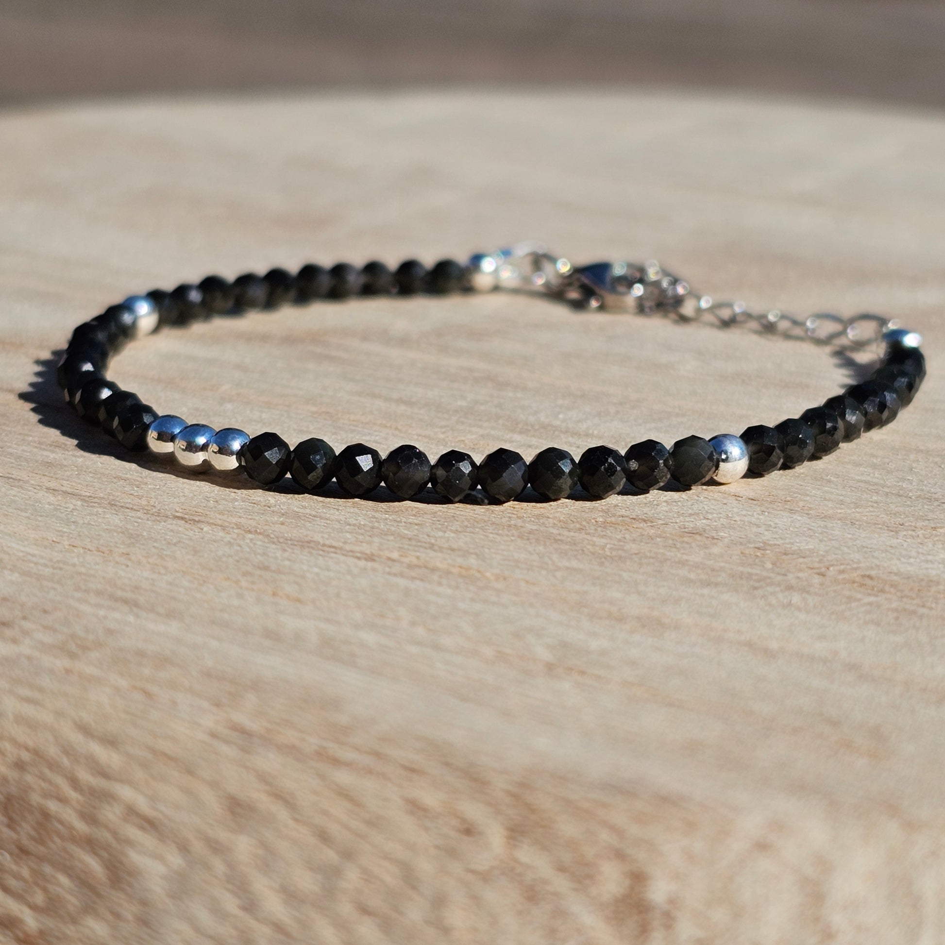 Delicate, faceted dainty Obsidian and AAA grade silver plated Hematite bead bracelet with a silver stainless steel clasp and extender chain.