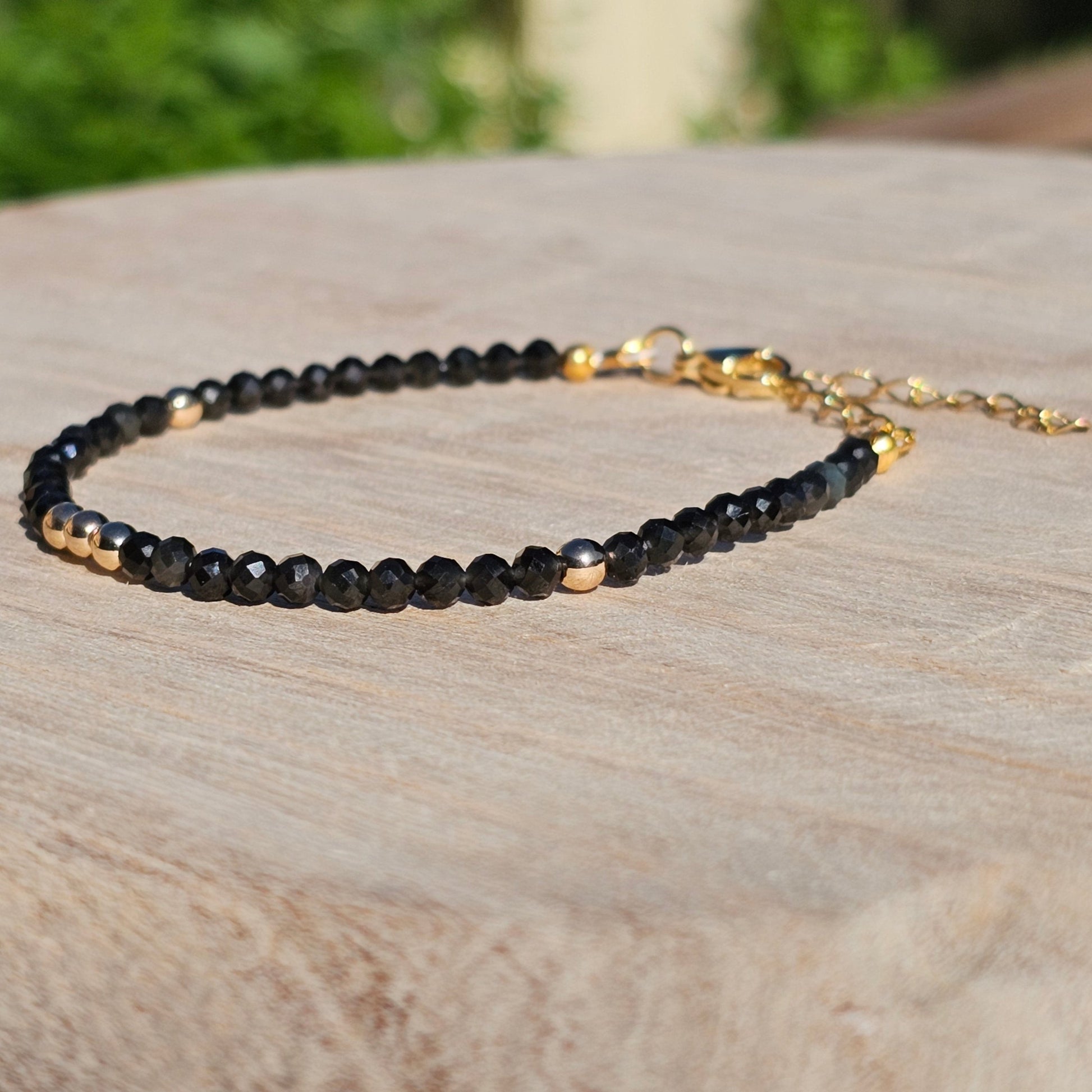 Delicate, faceted dainty Obsidian and AAA grade gold plated Hematite bead bracelet with a gold stainless steel clasp and extender chain.