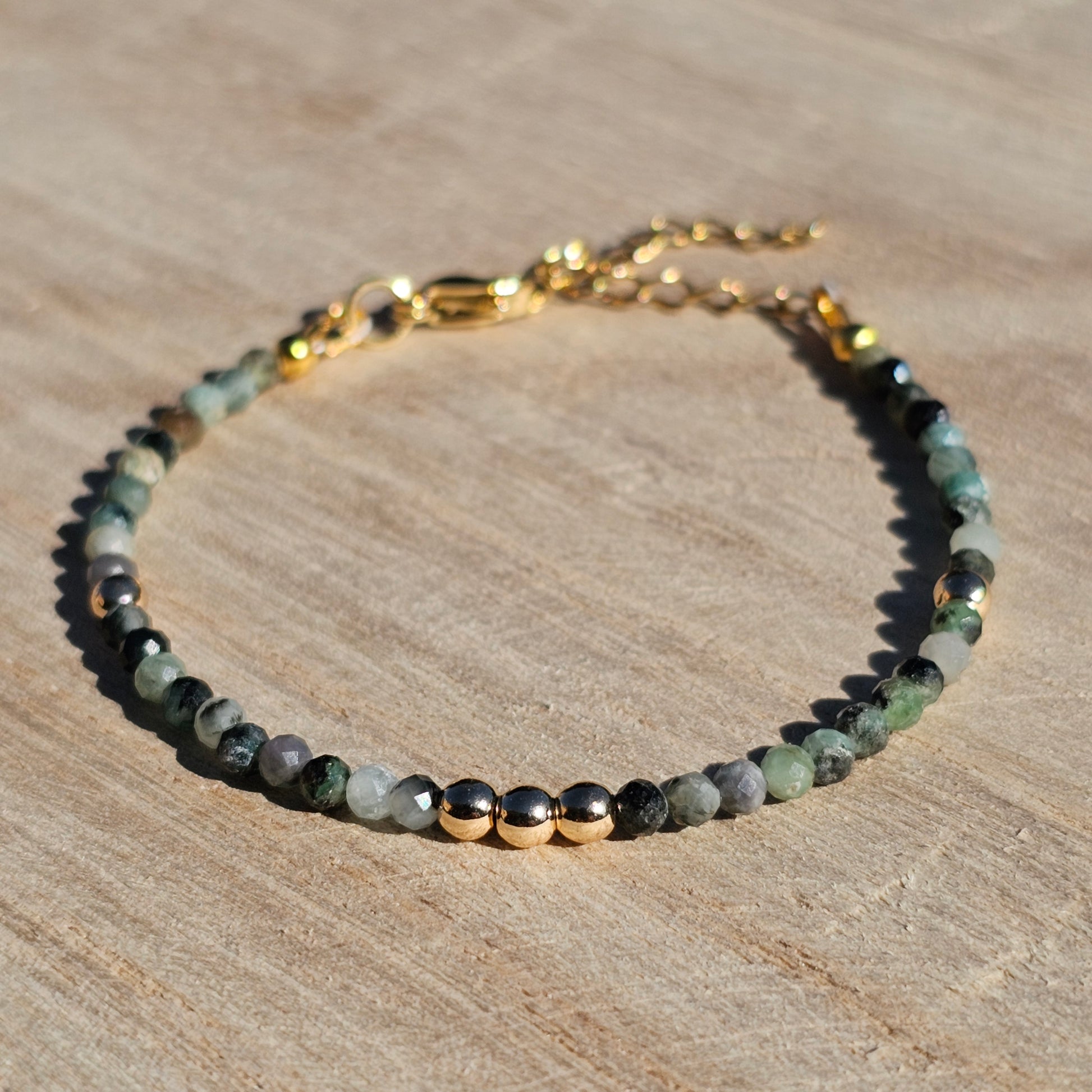 Delicate, faceted dainty Emerald and AAA grade gold plated Hematite bead bracelet with a gold stainless steel clasp and extender chain.