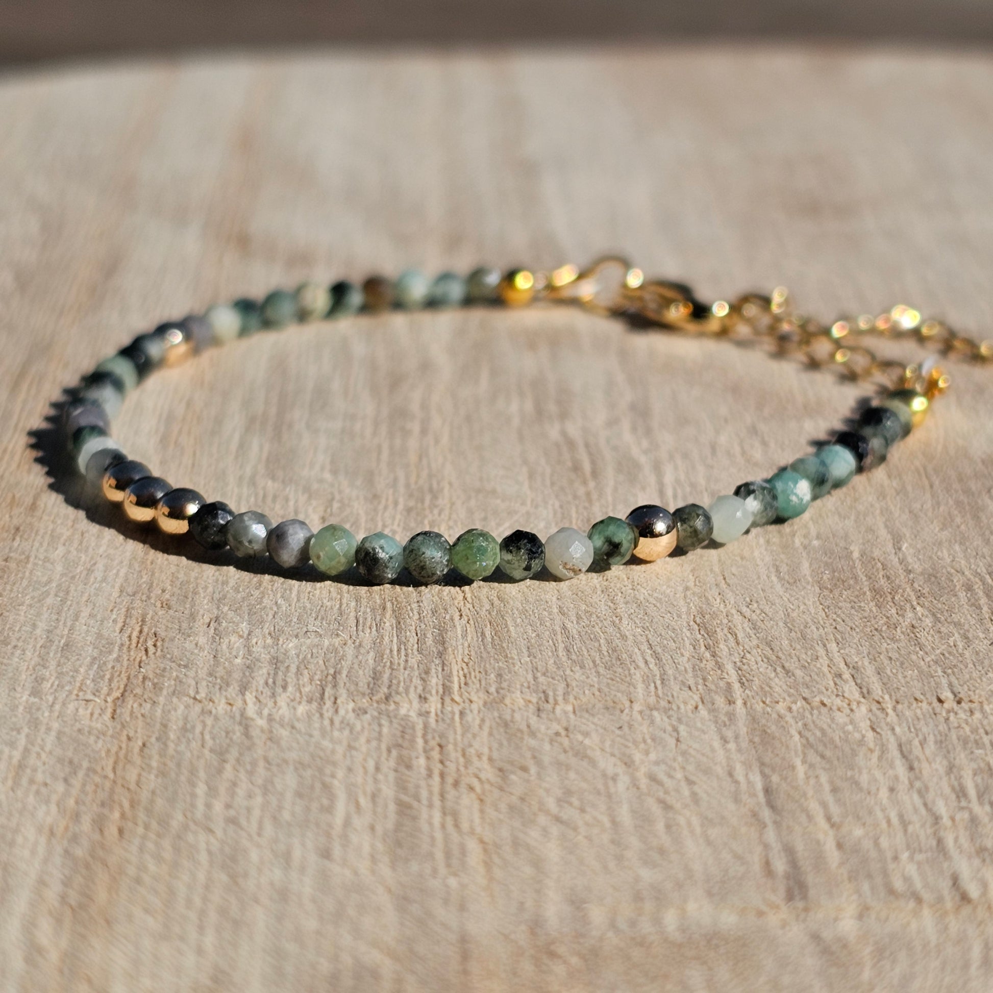 Delicate, faceted dainty Emerald and AAA grade gold plated Hematite bead bracelet with a gold stainless steel clasp and extender chain.