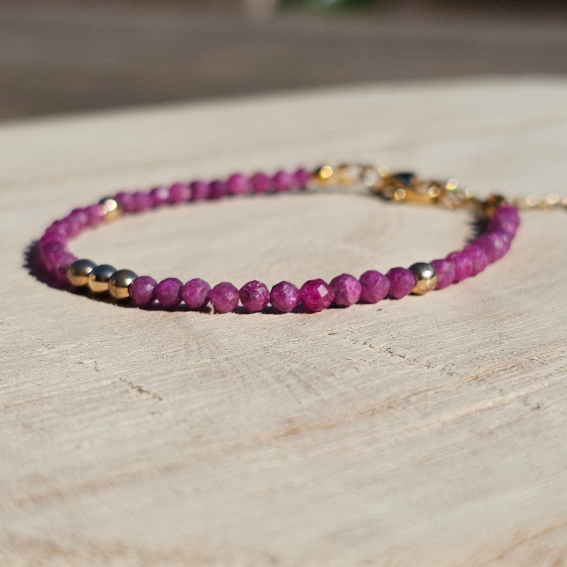 Delicate, faceted dainty Ruby and AAA grade gold plated Hematite bead bracelet with a gold stainless steel clasp and extender chain.