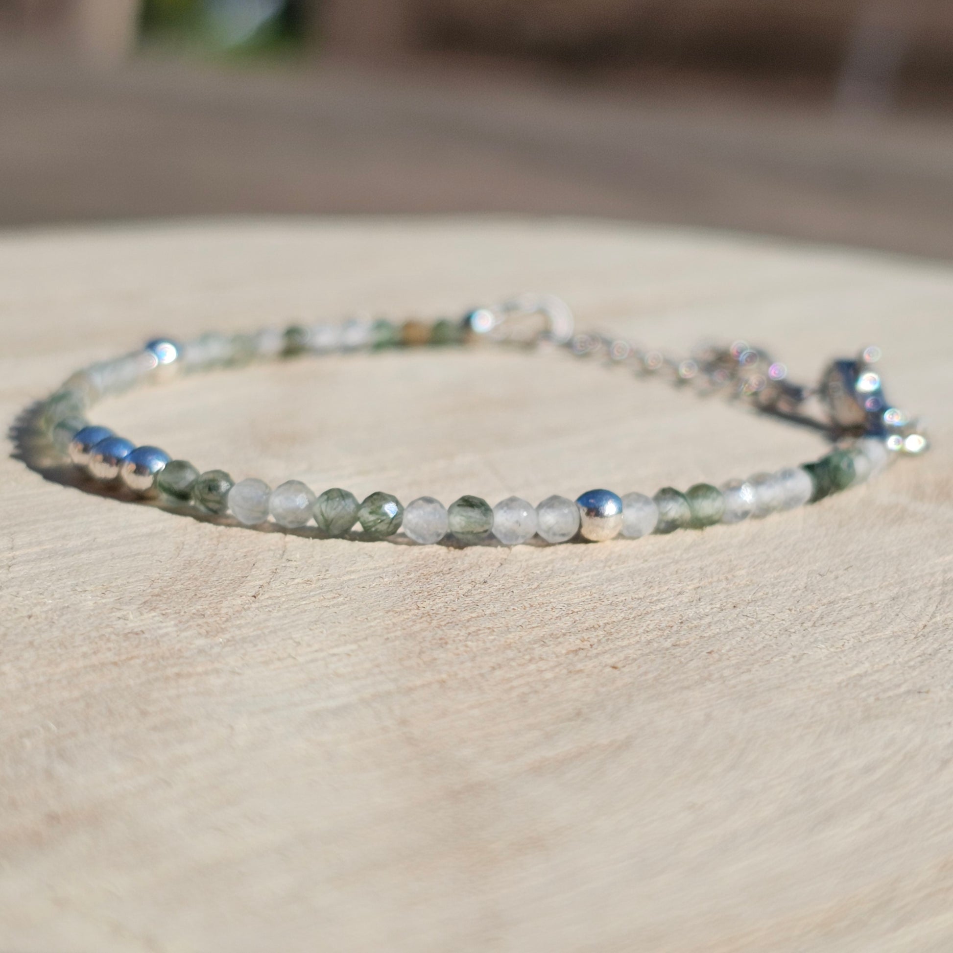 Delicate, faceted dainty green Rutile Quartz and AAA grade silver plated Hematite bead bracelet with a silver stainless steel clasp and extender chain.