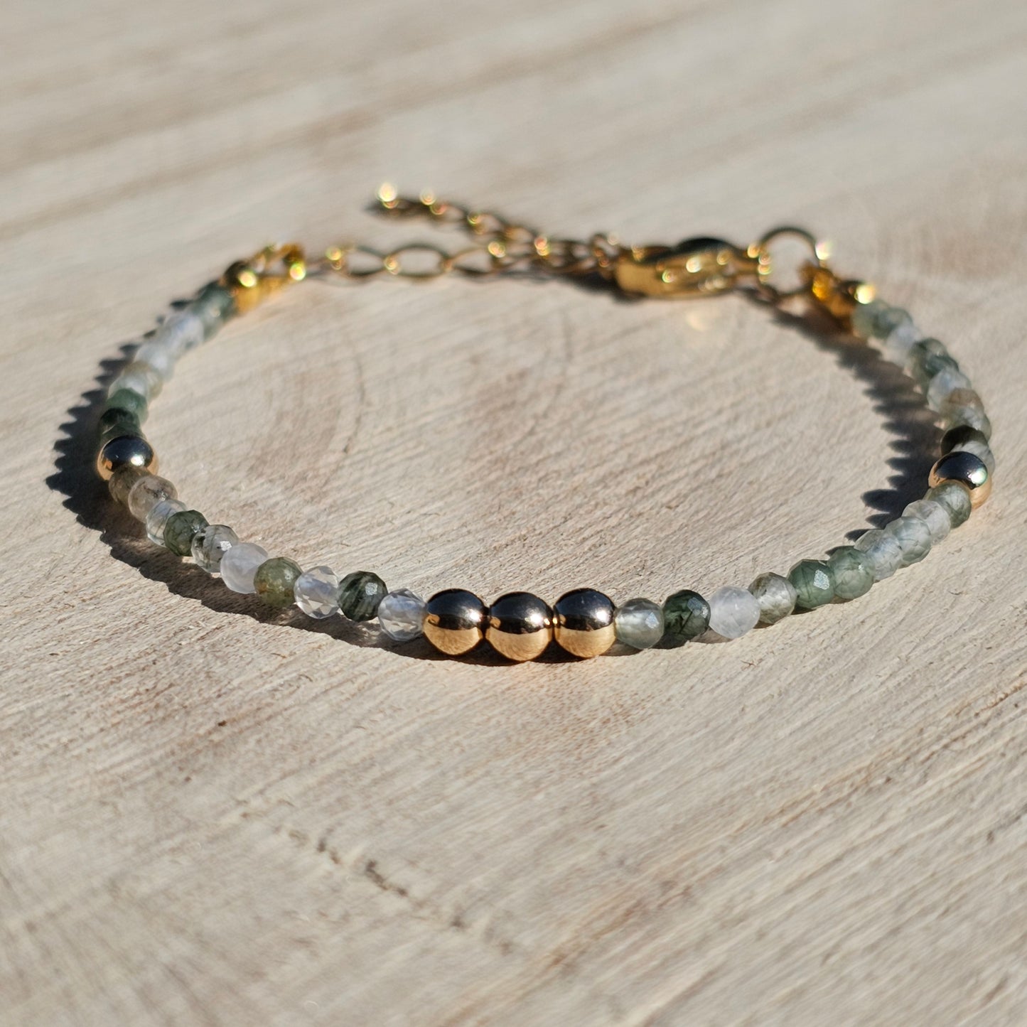 Delicate, faceted dainty green Rutile Quartz and AAA grade gold plated Hematite bead bracelet with a gold stainless steel clasp and extender chain.