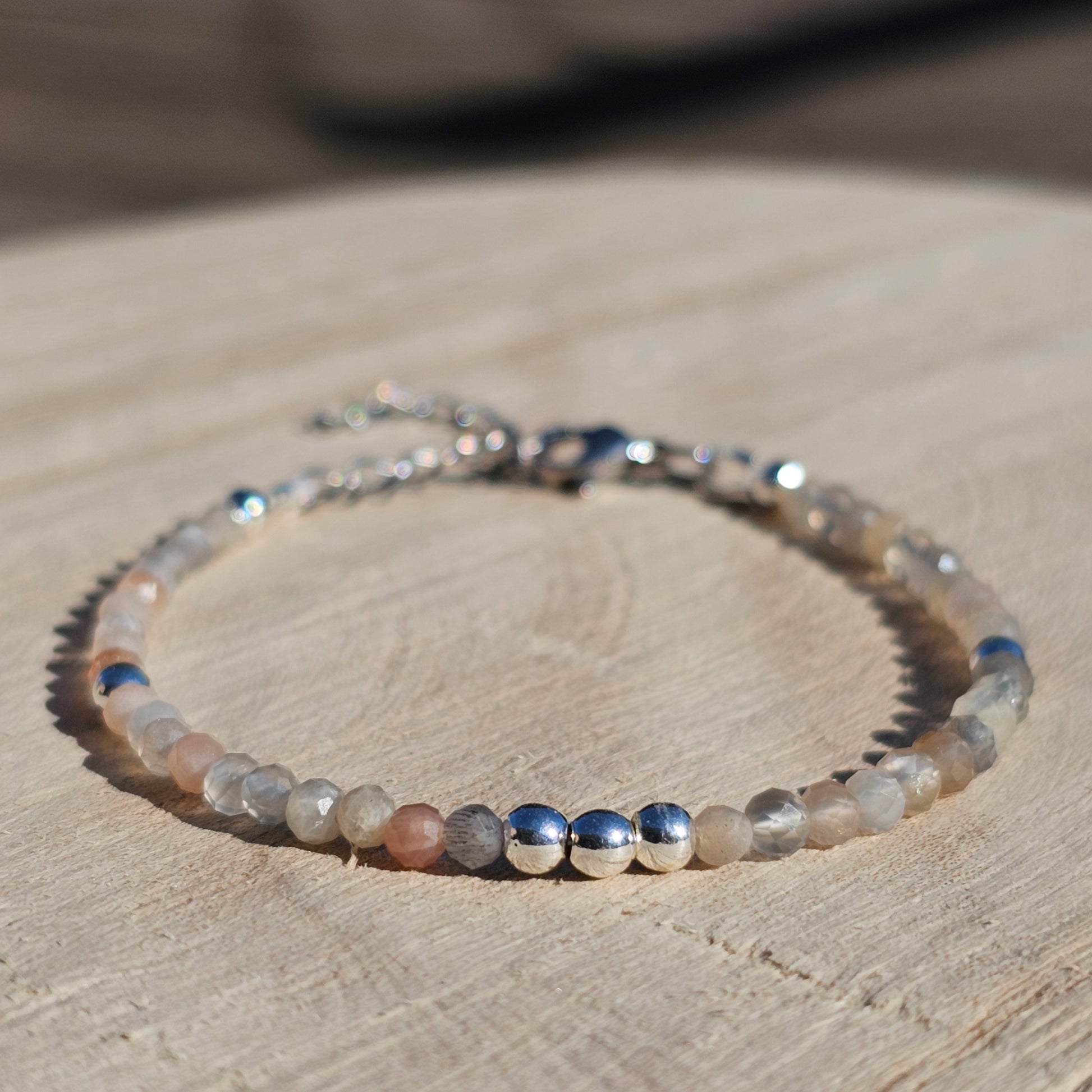 Delicate, faceted dainty Moonstone and AAA grade silver plated Hematite bead bracelet with a silver stainless steel clasp and extender chain.