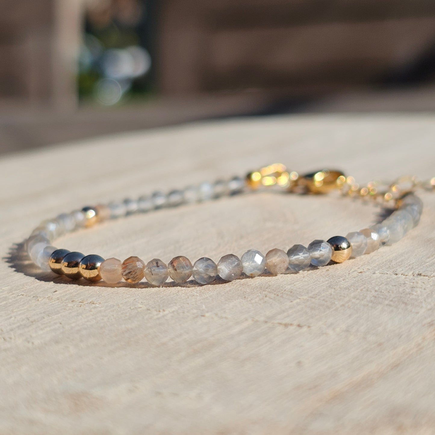 Delicate, faceted dainty Moonstone and AAA grade gold plated Hematite bead bracelet with a gold stainless steel clasp and extender chain.