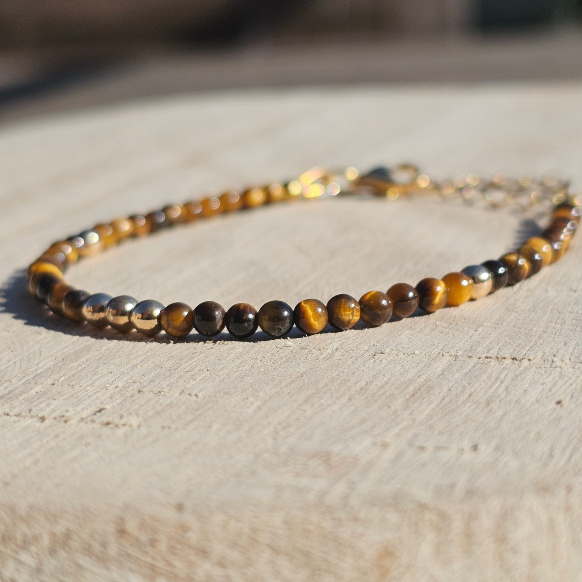 Delicate, round dainty AA Grade Tigers Eye and AAA grade gold plated Hematite bead bracelet with a gold stainless steel clasp and extender chain.